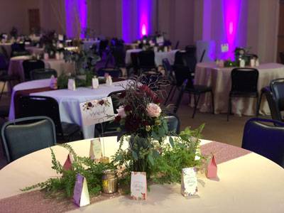 Decorated tables in The Pavilion Ballroom with floral centerpieces and purple accent lighting for an elegant event.