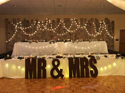 Ballroom at The Pavilion decorated for a wedding reception with string lights and large ‘Mr & Mrs’ letters in front of the head table