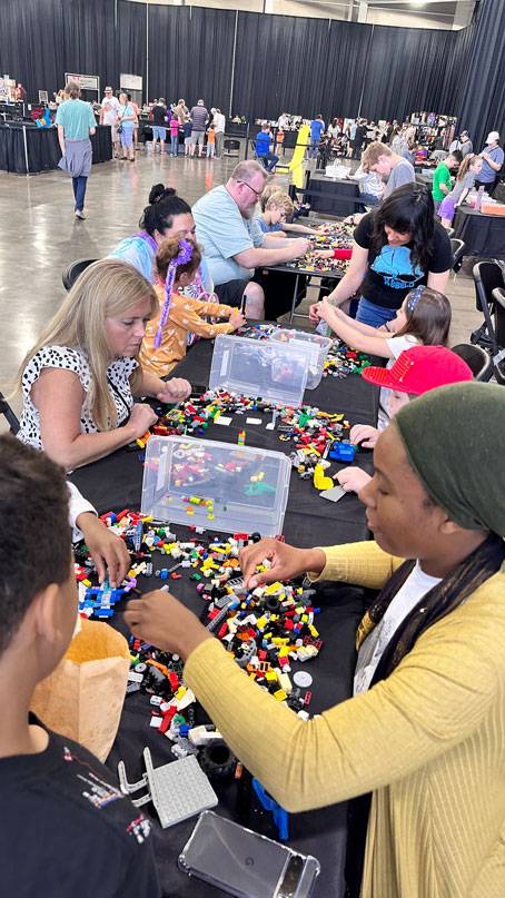 Families and children building with LEGO bricks during a community event inside The Pavilion Expo Hall.