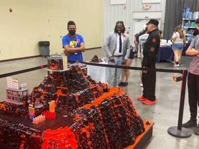 Visitors viewing a detailed LEGO volcano display during an event inside The Pavilion Expo Hall.